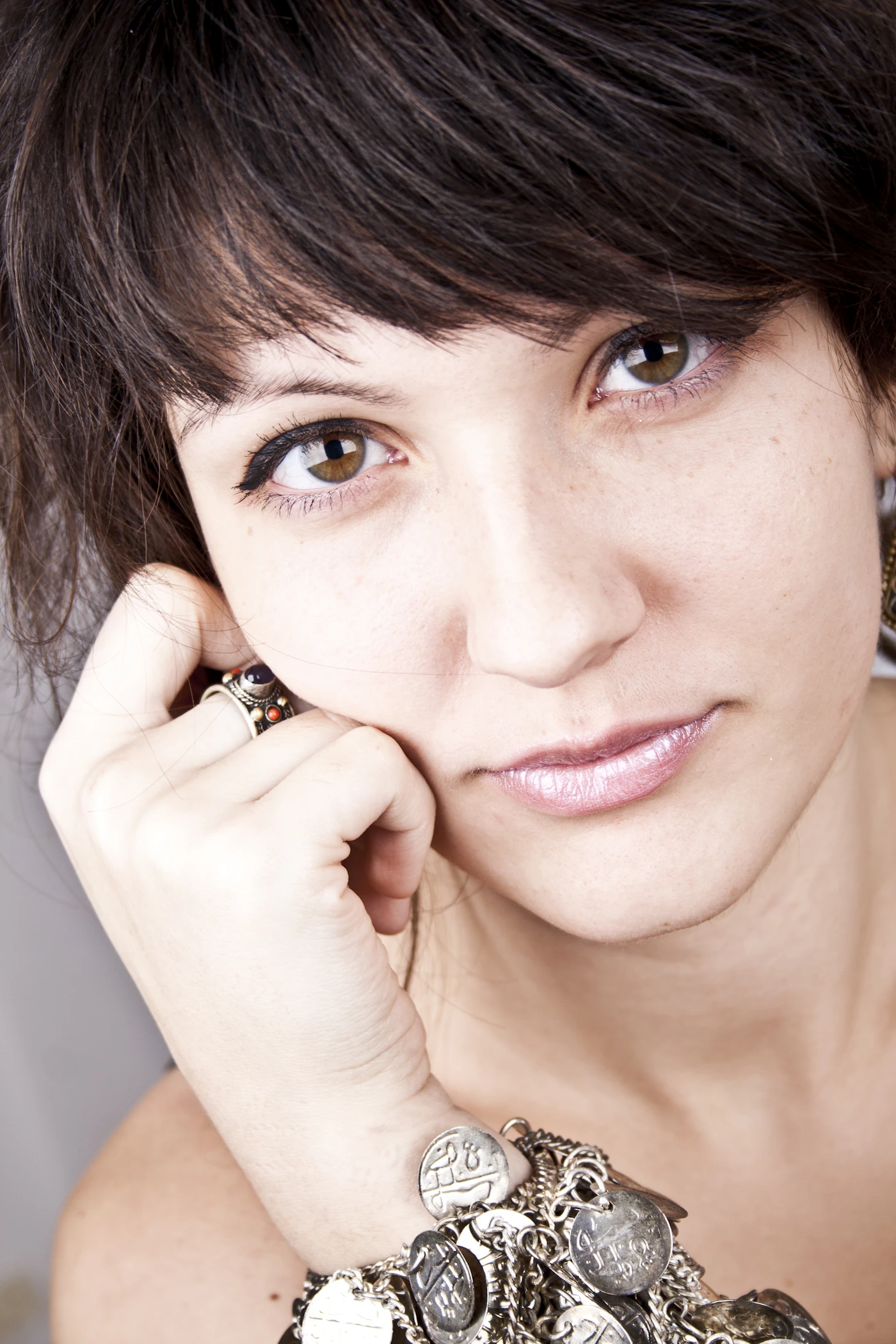 Woman resting her cheek on a hand with an ornate bracelet