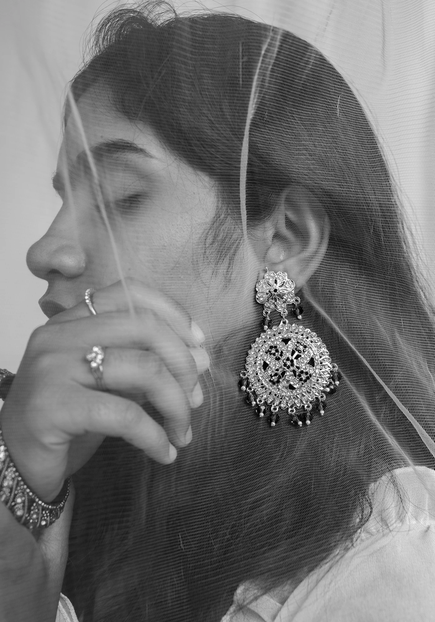 Black-and-white portrait of a woman wearing an ornate drop earring