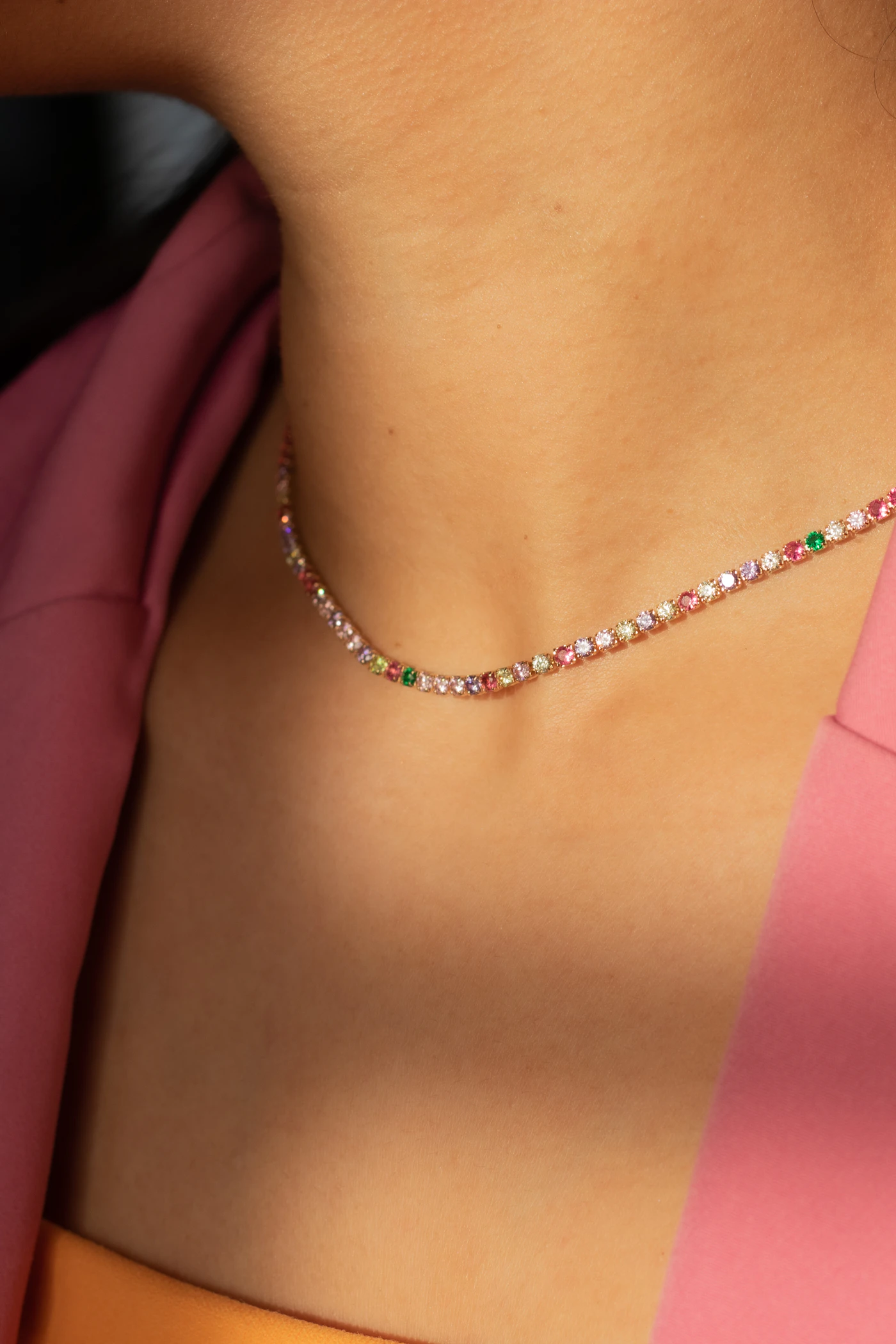 Close-up of a fine necklace styled with a burgundy jacket