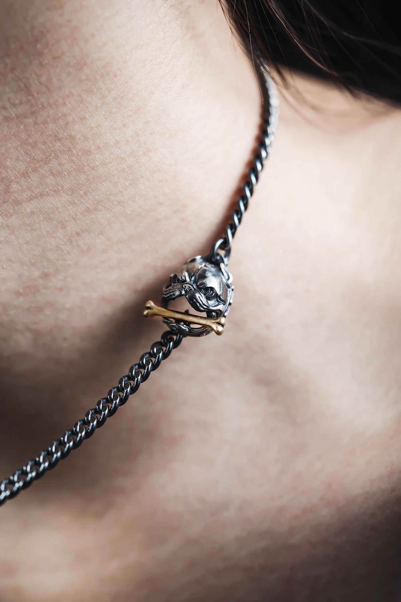 Detailed metal pendant on a dark chain