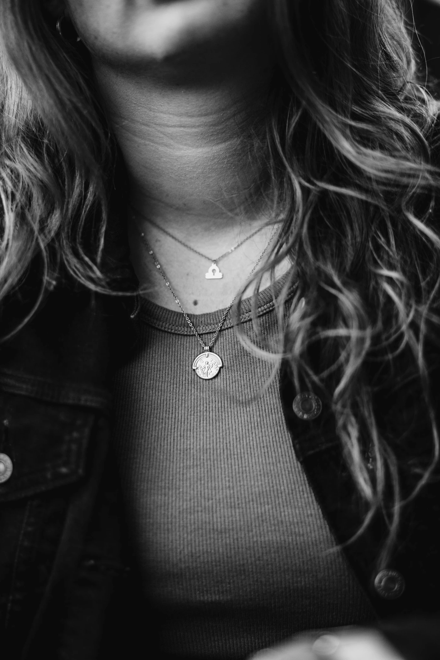 Layered necklaces worn over a dark top