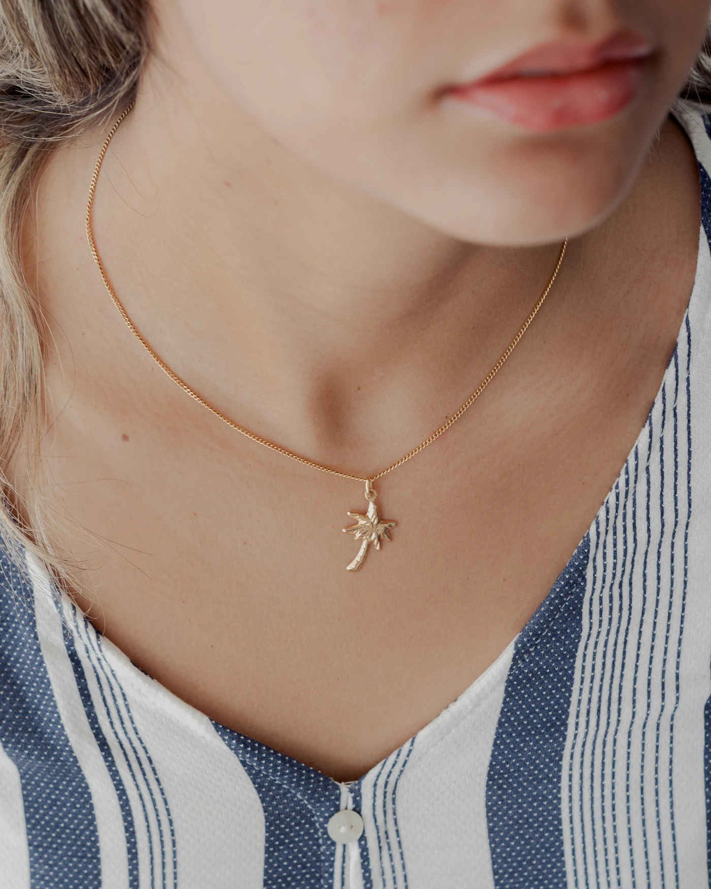 Small pendant necklace styled with a striped shirt